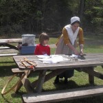 Macon helping visitor make colonial toy